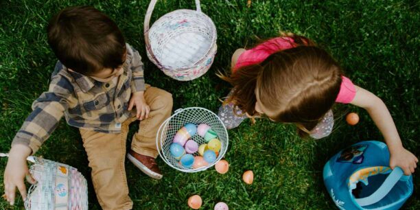 Children sitting in the grass with their easter baskets