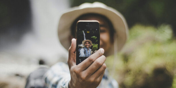 Person taking a picture of themself on cell phone for social media