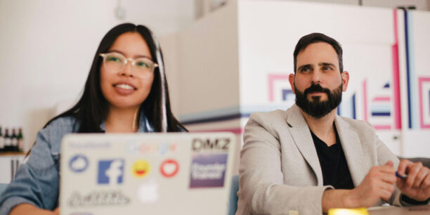 A man and woman looking up the latest nonprofit fundraising trends on their laptop