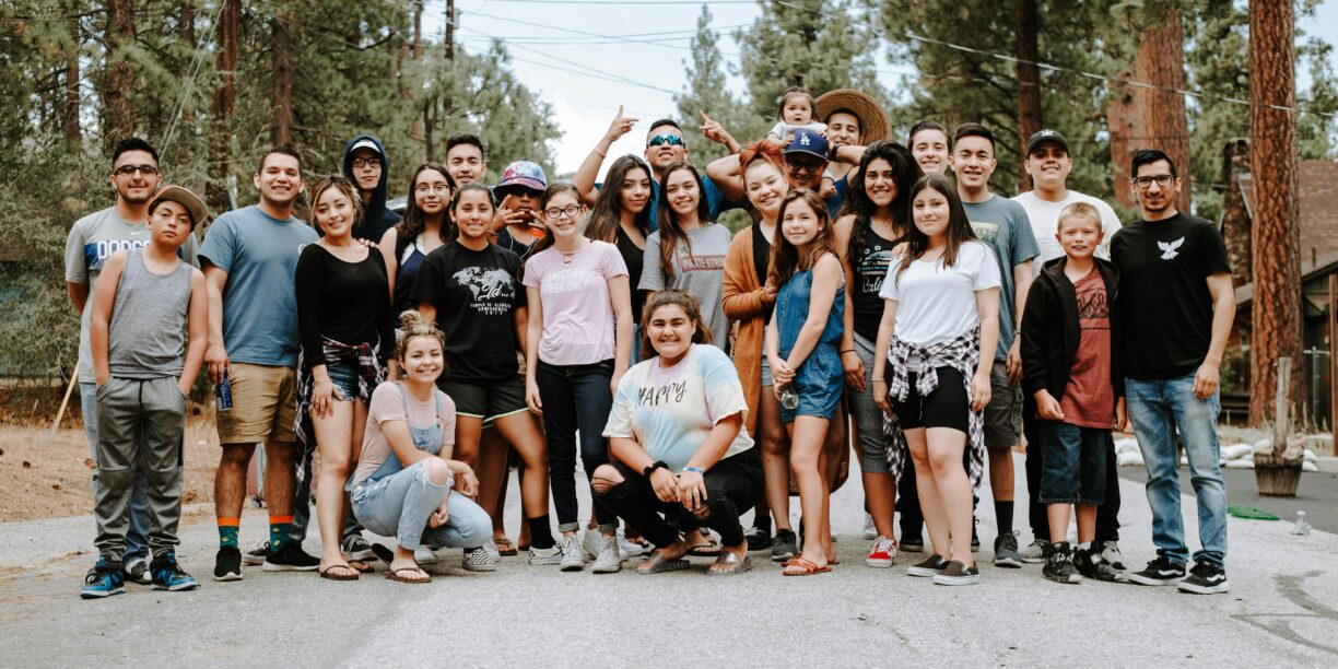 Community of peers standing together outside for a group photo