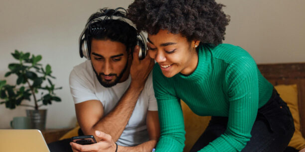 Woman in green sweater showing her fundraiser to a man in white tshirt