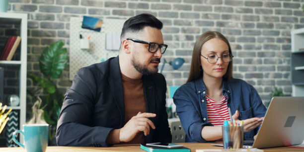 Man in blue jacket discussing donor engagement tactics with woman in denim shirt